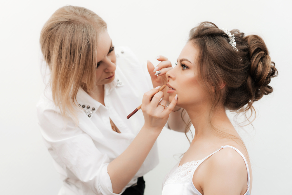 make up,artist,makes,up,and,paints,the,bride's,lips,with