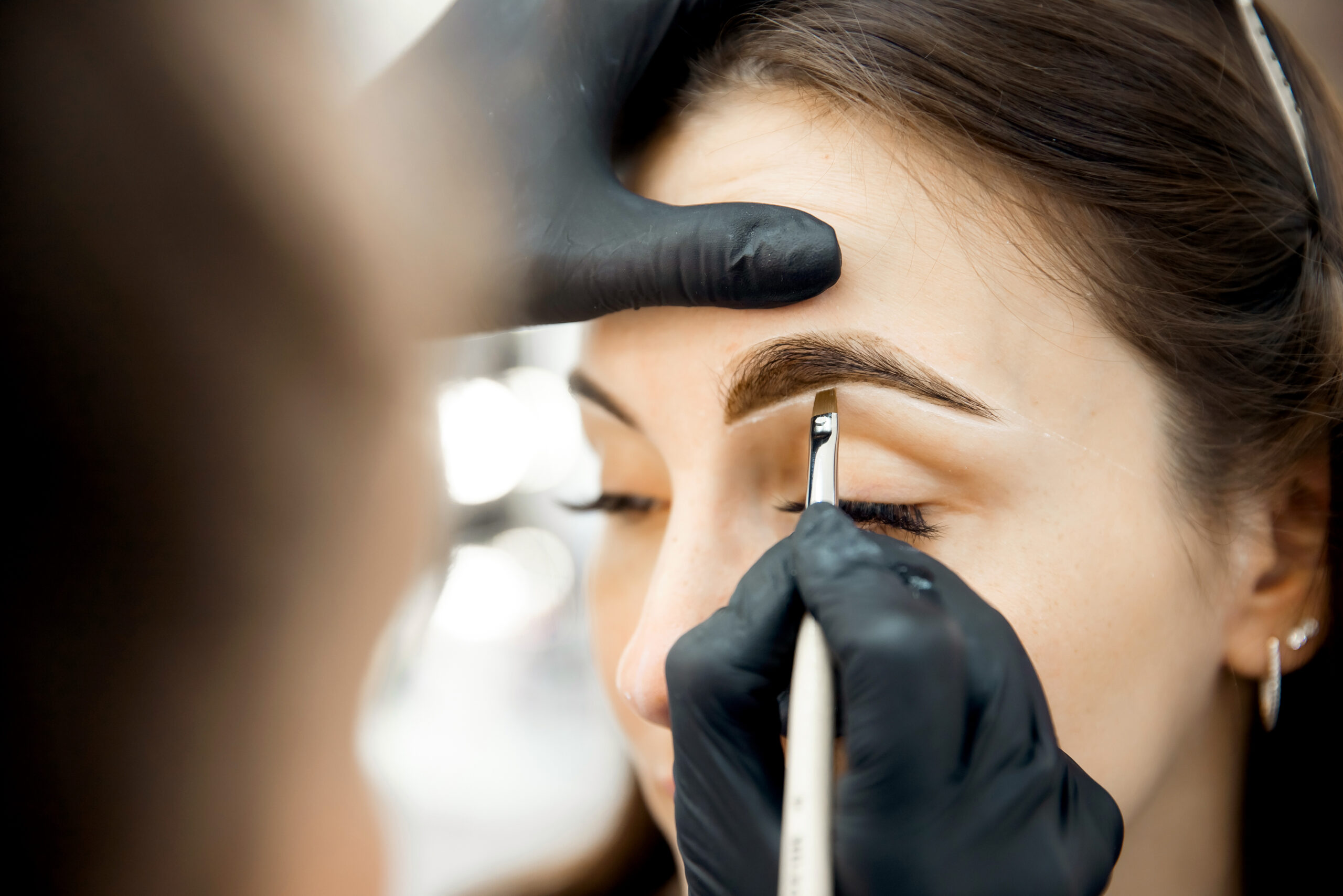 correction,and,tinting,eyebrows,,master,applies,thread,to,woman,on
