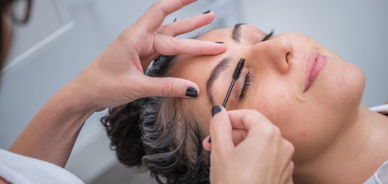 person brushing eyebrow