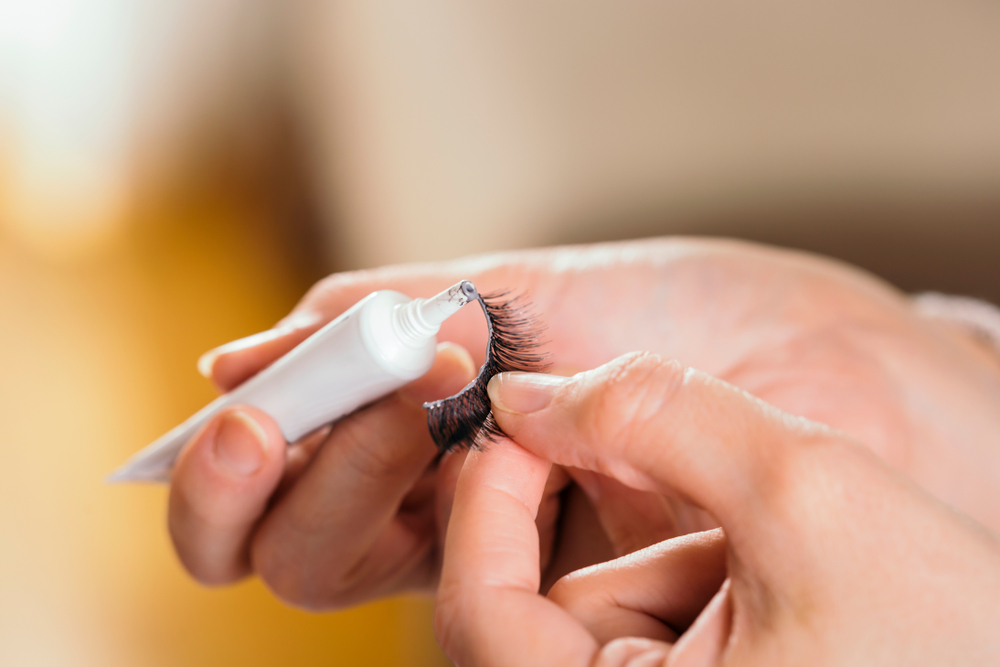 detail,of,make,up,artist's,hands,adding,glue,on,artificial