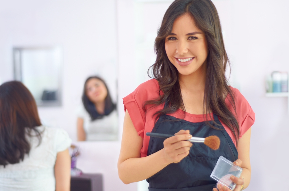 adding,a,touch,of,powder.,a,young,makeup,artist,standing