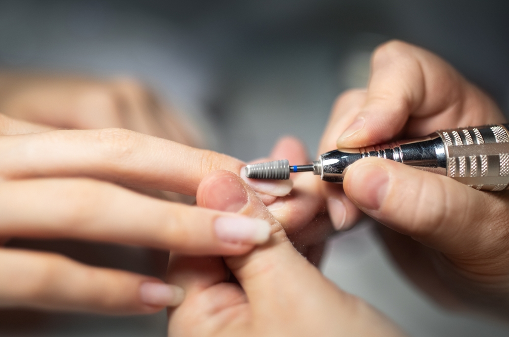 nails,polish,procedure.,closeup,of,female,hands,while,manicurist,filing